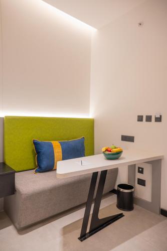 a bench in a room with a green wall at Zibe Luxe Kakinada by GRT Hotels in Kākināda