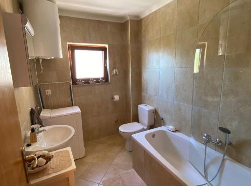 a bathroom with a tub and a toilet and a sink at Villa Oliva in Gruda