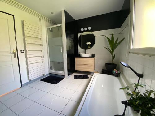 une salle de bain avec une baignoire, un lavabo et un miroir dans l'établissement Maison vue mer, port et ville, à Fécamp