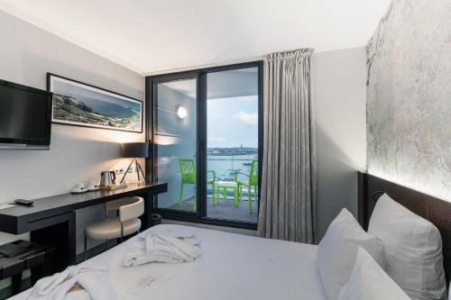 a hotel room with a bed and a view of the water at Le Thalassa Hôtel & Spa in Camaret-sur-Mer