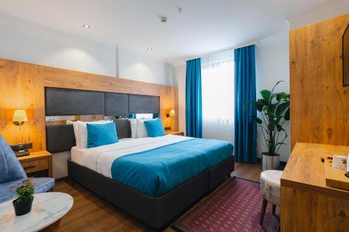 a bedroom with a large bed with blue pillows at Berlin Suite Hotel Trabzon in Trabzon