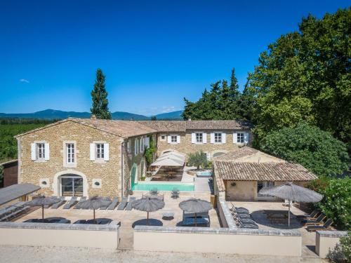 an external view of the house with umbrellas and a swimming pool at Mas Loisonville - Demeure d'exception & Spa en Drôme Provençale in Grillon