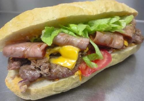 a sausage sandwich with lettuce and peppers on a bun at Paso a Paso in Terlizzi