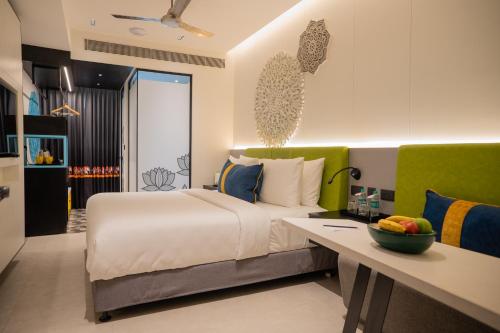 a bedroom with a bed and a desk in a room at Zibe Luxe Kakinada by GRT Hotels in Kākināda
