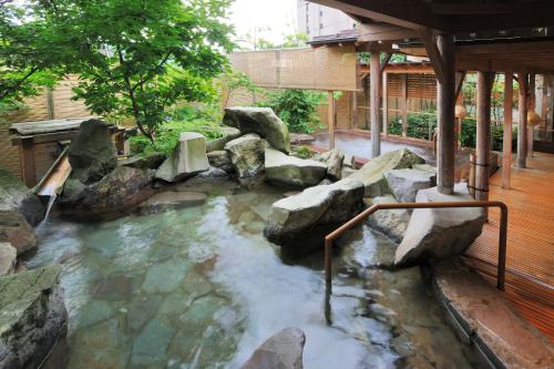 a pool of water with rocks in a yard at Yuzawa Grand Hotel in Yuzawa