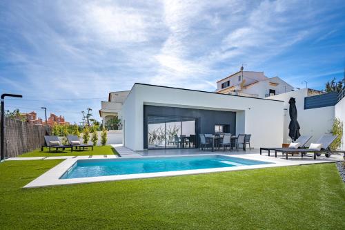 a backyard with a swimming pool and a house at Host Wise - Bright Spacious House Swimming Pool in Porches