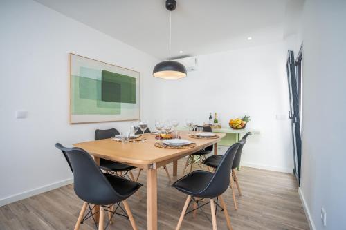a dining room with a wooden table and chairs at Host Wise - Bright Spacious House Swimming Pool in Porches