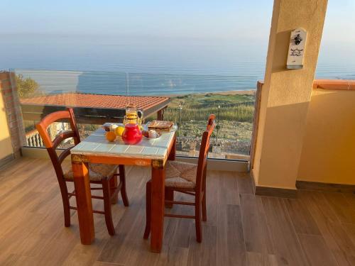 a table and chairs with a plate of food on a balcony at Re Mare B&B in Crotone