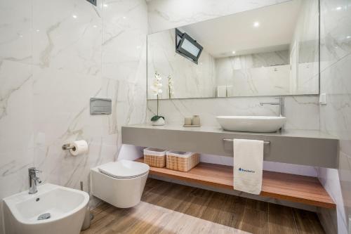 a white bathroom with a sink and a toilet at Host Wise - Bright Spacious House Swimming Pool in Porches
