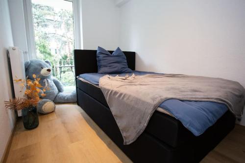 een slaapkamer met een bed met een teddybeer naast een raam bij Traumhafte Stadtwohnung in Duisburg