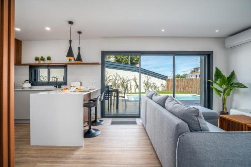 a kitchen and living room with a couch and a table at Host Wise - Bright Spacious House Swimming Pool in Porches