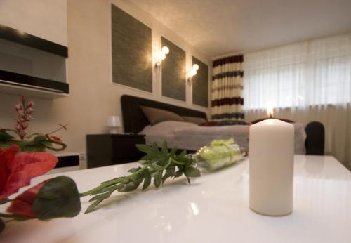 a white candle sitting on a table in a living room at Palatium Bad Ems in Bad Ems