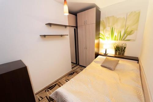 um pequeno quarto com uma cama no canto em Апартамент за гости Уют em Burgas