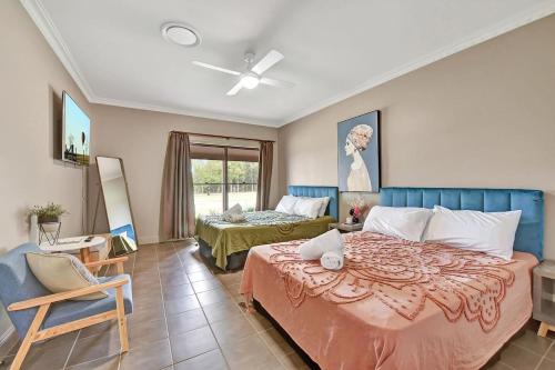 a bedroom with a large bed and a chair at 5br Bbq Hot Tub Family Farm Stay Homestead in Lovedale