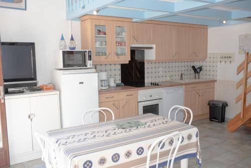 une cuisine avec une table et une cuisinière four supérieur dans l'établissement Charmante Villa patio en bordure de forêt, à Capbreton