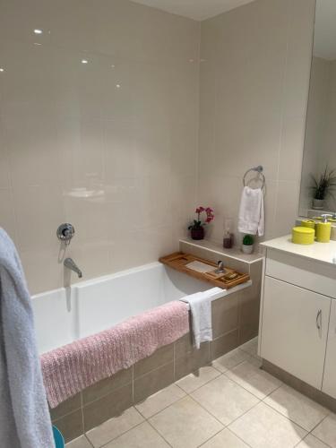 La salle de bains est pourvue d'une baignoire et d'un lavabo. dans l'établissement Amazing water view class large holiday home, à Gold Coast