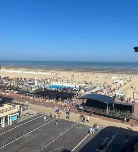 a crowd of people on a beach near the ocean at Oostduinkerke Apartments in Oostduinkerke