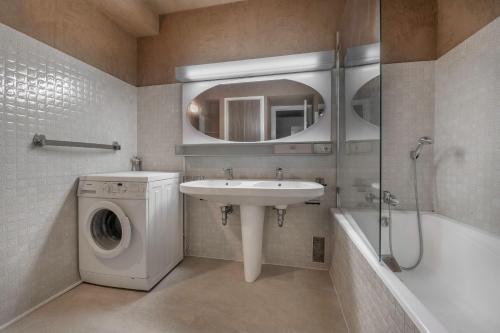 une salle de bain avec un lavabo et une machine à laver dans l'établissement Splendide vue mer et en front de plage!, à La Baule