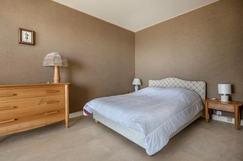 - une chambre avec un lit, une commode et une lampe dans l'établissement Splendide vue mer et en front de plage!, à La Baule
