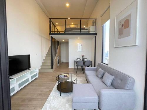 a living room with a couch and a tv at Siamese 87 2BR 素坤逸 BTS On Nut LOFT 两房 25 in Bangkok