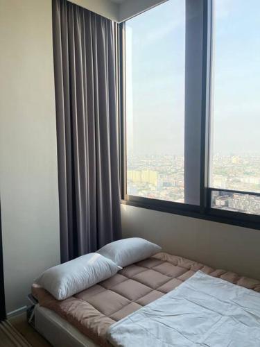 a bed in a room with a large window at Siamese 87 2BR 素坤逸 BTS On Nut LOFT 两房 25 in Bangkok