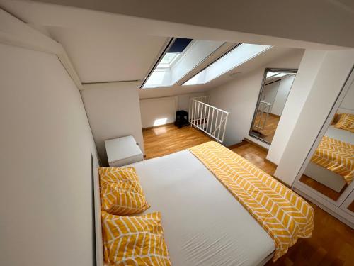 a bedroom with a large white bed with yellow pillows at Apartman Mak in Mostar