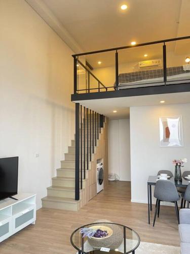 a living room with a staircase and a living room with a couch at Siamese 87 2BR 素坤逸 BTS On Nut LOFT 两房 25 in Bangkok