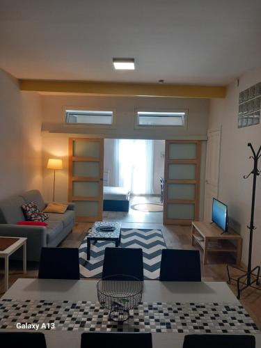 una sala de estar con un sofá y una mesa en T3 pratique, Garage gratuit, Esprit Auber, en Béziers