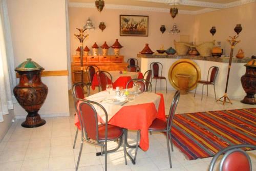 Hotel Aladarissa Ait Baha في Aït Taksimt: غرفة طعام مع طاولة وكراسي في غرفة