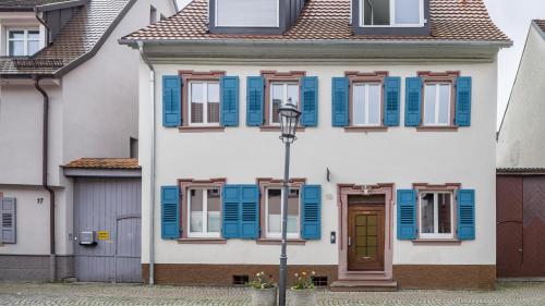 una casa con persianas azules y una puerta en Altstadttraum, en Endingen am Kaiserstuhl