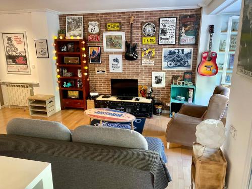 - un salon avec un canapé et un mur de guitare dans l'établissement Apartamento estilo Vintage céntrico y garage incluido, à Logroño