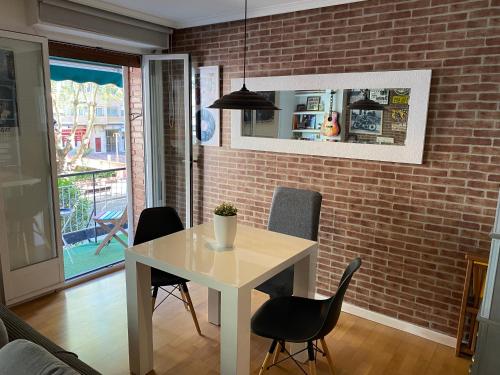 - une table et des chaises dans une pièce dotée d'un mur en briques dans l'établissement Apartamento estilo Vintage céntrico y garage incluido, à Logroño