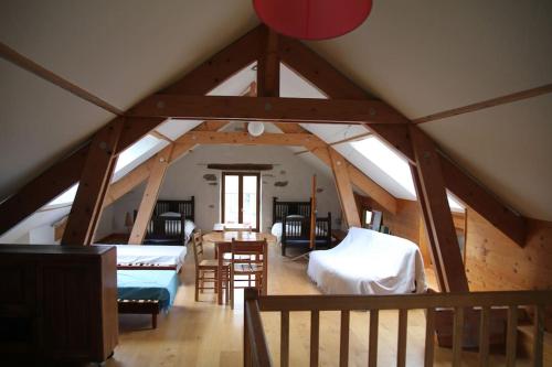une chambre mansardée avec deux lits et une table dans l'établissement Maison de campagne bucolique et ressourçante, à Sainte-Hélène-du-Lac