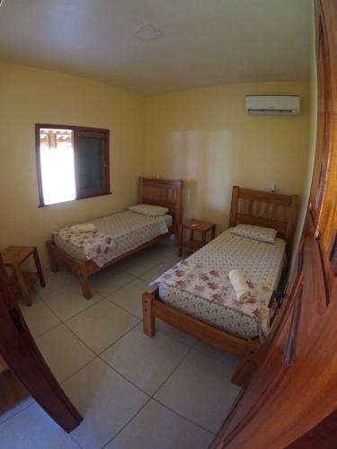 a room with two beds and a mirror at Bahia Haus Don Pietro in Canavieiras
