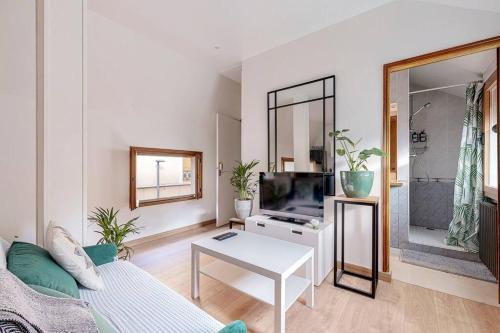 un salon avec un canapé et une télévision dans l'établissement Very Quiet and Cosy Big Apartment, à Saint-Ouen