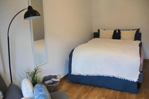 Dormitorio con cama con espejo y lámpara en Zentral, free Parking, WIFI, nähe Bahnhof, Shops, en Frutigen