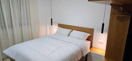 1 dormitorio con cama blanca y ventana en La Paloma Blanca en Tetuán