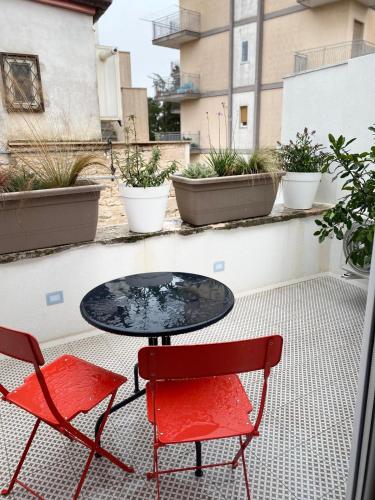 two red chairs and a table on a balcony at Paso a Paso in Terlizzi