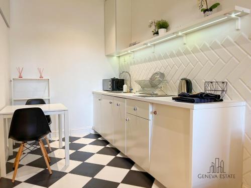 a kitchen with white cabinets and a checkered floor at 5Seasons Apartments Krakow Center in Krakow