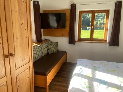a bedroom with a bed and a tv on a wall at Hansenbauernhof in Ruhpolding