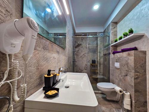 a bathroom with a shower and a white sink at Double View Apartment Mamaia in Mamaia