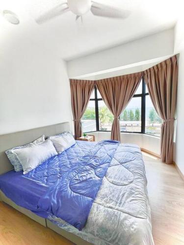 a bedroom with a bed with a blue comforter at Mutiara Melaka Beach Resort-Rumah Bonda Ohana in Malacca
