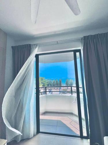 a room with a door open to a balcony at Mutiara Melaka Beach Resort-Rumah Bonda Ohana in Malacca
