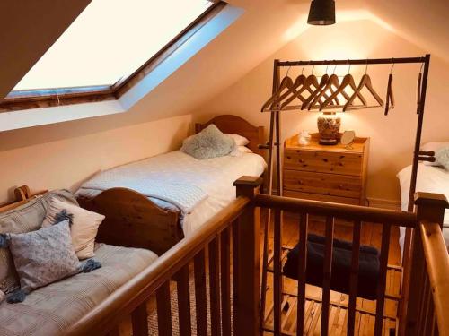 a attic room with a bed and a window at Harvel Cottage in Paulton