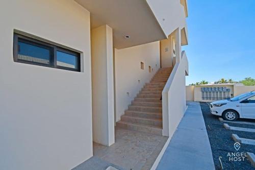 a house with stairs and a car parked in a driveway at Oceanview Stay, Satellite Internet, Steps to Beach in El Sargento