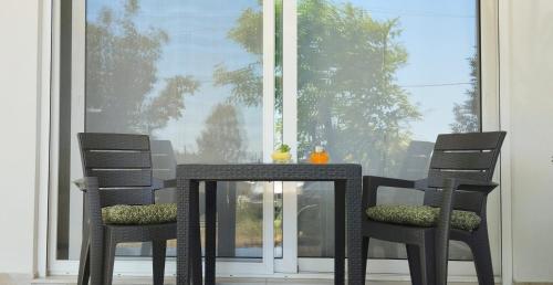 a table and two chairs in front of a window at Lovely Place in Acharnes