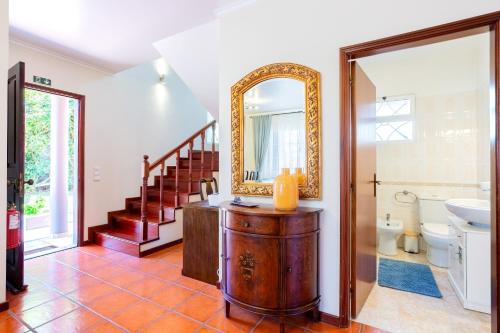 y baño con lavabo y espejo. en Tranquil Oasis: 3 BR Sea View Villa with Lush Yard en Funchal