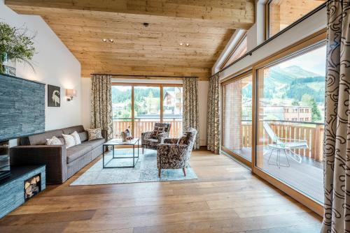 a living room with a couch and a table at Hotel Auenhof in Lech am Arlberg