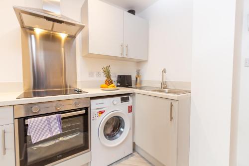 a kitchen with a washing machine and a sink at Boutique 1BR Apartment in the heart of Preston in Preston