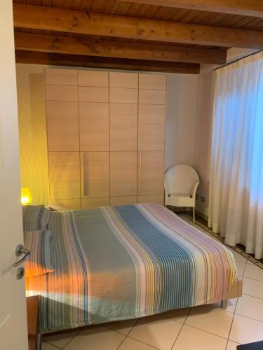 a bedroom with a bed and a chair at VILLA CAMPESTRE in Colombaro